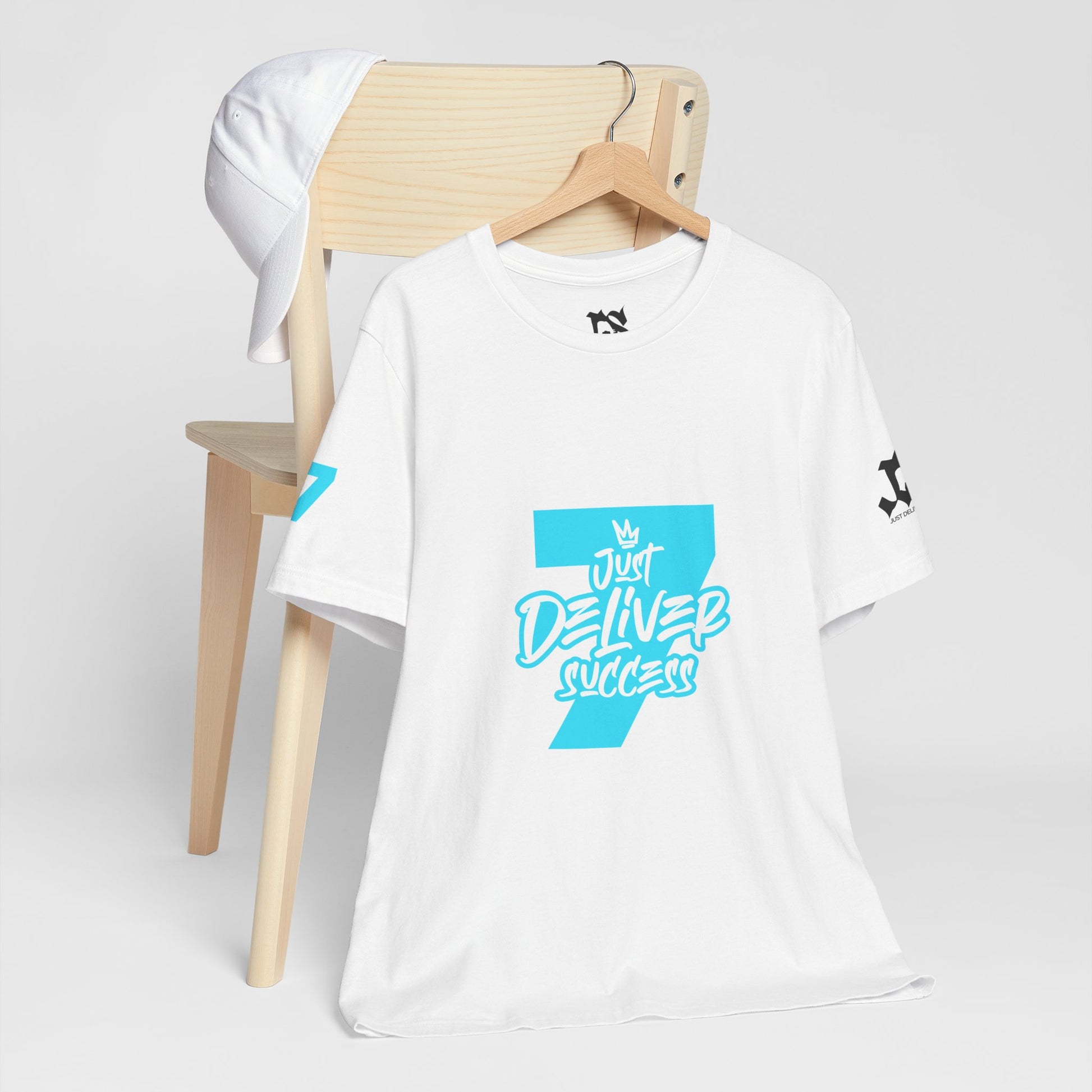 Just Deliver Success Light Blue That City 7 Summer Collection t-shirt displayed on a wooden chair with matching cap.